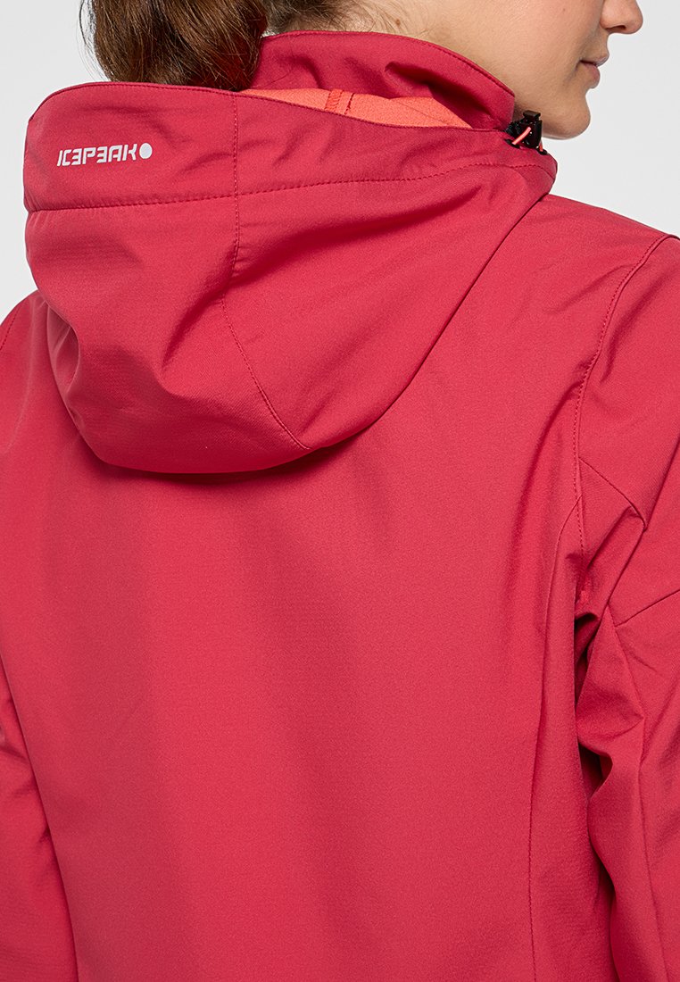 Rote wasserdichte Jacke mit einer Kordelzugkapuze, glatter Textur und Logodetail auf der Rückseite. Das Design umfasst kontrastierende orangefarbene Akzente.