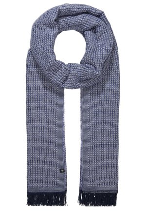 Modrošedá tkaná šála s geometrickým vzorem, třásněmi na koncích a volně uvázaná do uzlu.