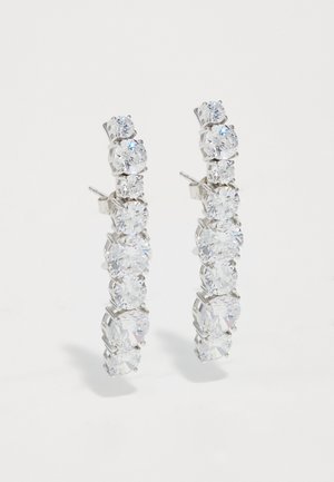 Przezroczyste kolczyki w kształcie obręczy z kryształu, z metalowym wykończeniem w kolorze srebra, z liniowym ułożeniem okrągłych kamieni w różnych rozmiarach.