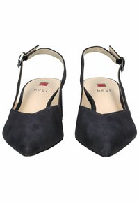 Scarpe slingback in suede nero con punta affusolata, cinturino regolabile e una fodera interna smussa con un piccolo dettaglio del logo rosso.