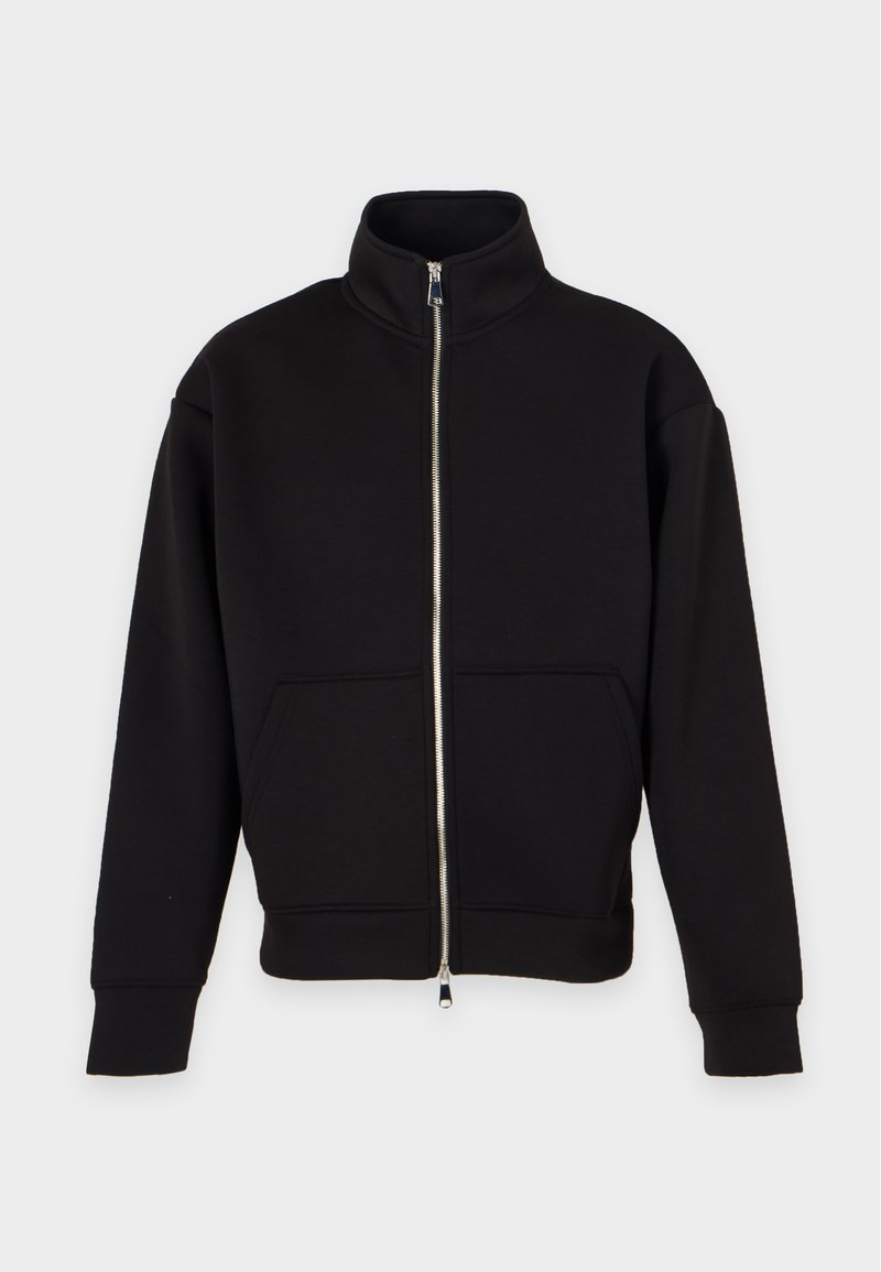 Schwarze Jacke mit Reißverschluss, hohem Kragen, langen Ärmeln und Fronttaschen, vor einem schlichten hellen Hintergrund gezeigt.