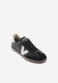 Svart sneakers med vit V-logotyp, material av mocka och läder, snördesign, grå gummisula, vadderad tunga och krage.