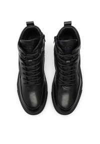 Melnas ādas augstās kurpes ar auklu stiprinājumu priekšpusē un rāvējslēdzēja detaļām. Gluda tekstūra, apaļa purngala daļa un izturīga gumijas zole.