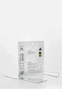 Zestaw kosmetyków Reedle Shot w srebrno-białym opakowaniu. Zawiera kroki serum i maseczki, z wyraźnym nadrukiem i zielonymi akcentami. Dwa lusterka poniżej.