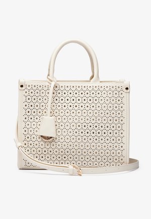 Kremowa torba na ramię z perforowanym geometrycznym wzorem, podwójnymi uchwytami, zawieszką oraz regulowanym długim paskiem na ramię.