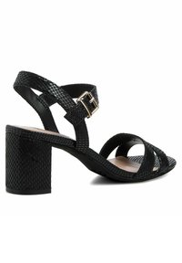 Sandales à talons noires avec un design à lanières croisées, motif reptilien texturé, détail de boucle et un talon carré pour la stabilité.