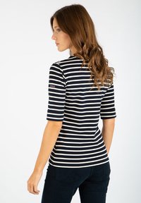 Maglietta a maniche corte a righe navy e bianche con collo girocollo, realizzata in tessuto leggero, con un piccolo logo sulla spalla sinistra.