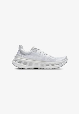 Scarpa da ginnastica bianca con suola spessa e ventilata, tomaia in mesh, design con lacci e motivo sottile vicino al tallone, vista di profilo su sfondo bianco.