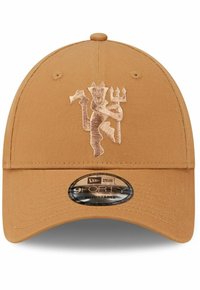 Beige Baseballmütze mit einem gewölbten Schild, die ein erhaben gesticktes Emblem in Hellbraun zeigt. Verstellbarer Riemen hinten. New Era Branding ist sichtbar.