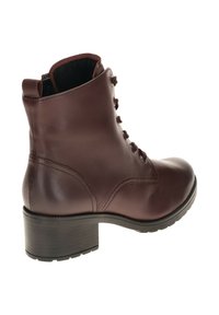 Bruine leren enkellaars met een ronde neus, vetersluiting, lage blokhak en een terreinstructuur onder de zool. Heeft een gevoerde kraag voor extra comfort.