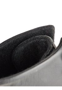 Interno di stivale in pelle nera con una morbida fodera in feltro nero, caratterizzato da bordi arrotondati e costruzione senza cuciture per il massimo comfort.