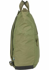 Mochila de nylon verde con una forma aerodinámica, que cuenta con un cierre de cremallera, bolsillo lateral, pequeña etiqueta decorativa y un asa resistente en la parte superior.