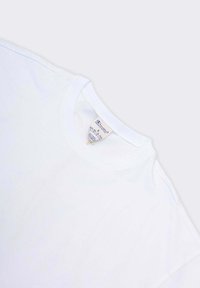 T-shirt bianco in cotone con scollo rotondo e maniche corte. Il tessuto sembra liscio; etichetta visibile vicino allo scollo, con indicazioni su taglia e istruzioni per la cura.