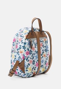 Sac à dos à motif floral en bleu clair, avec des fleurs roses et jaunes, des sangles en cuir marron et une poche zippée à l'avant.