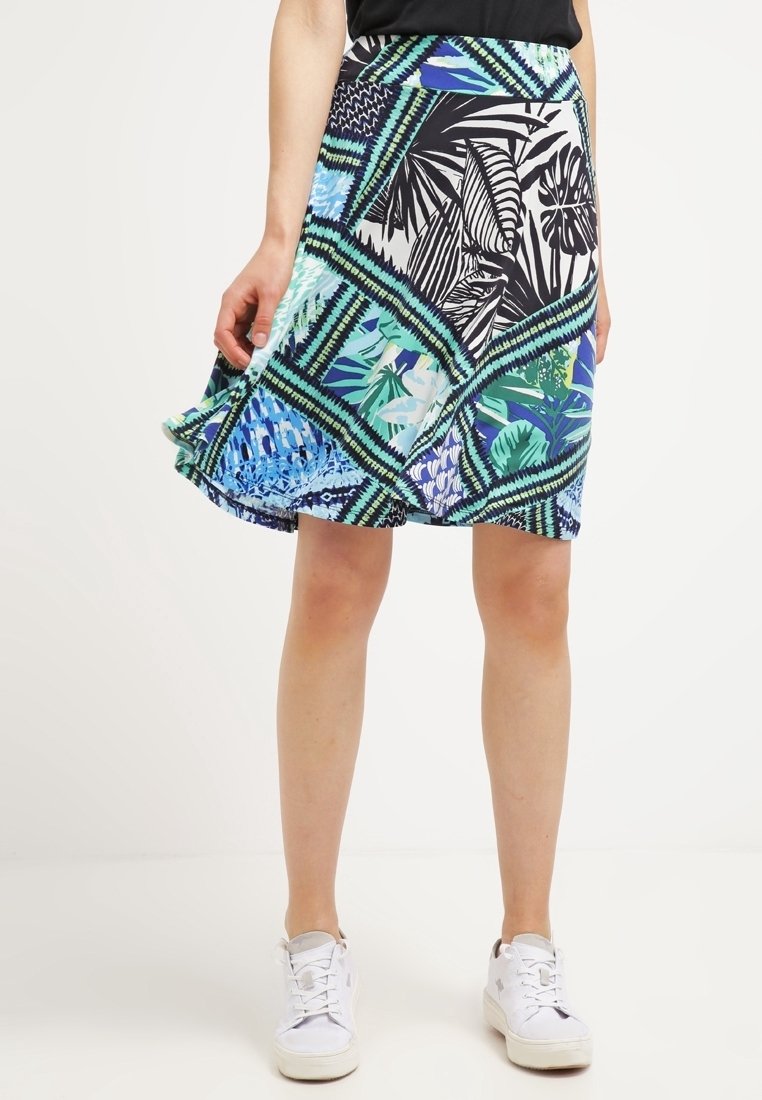 Une jupe évasée jusqu'aux genoux avec un motif floral géométrique multicolore mettant en valeur des accents verts, bleus et noirs. Fabrication en tissu léger.
