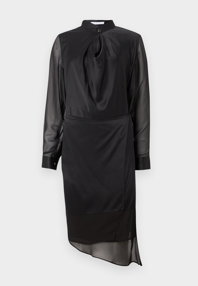Black dress with a high collar, long sheer sleeves, and a knot detail at the neckline. Features a layered hemline and smooth fabric texture.