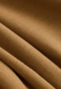 Beež kanga tekstuurse koega, millel on pehmed, sujuvad voldid ja peen, ühtlane detailide muster. Ideaalne rõivaste või polsterduse jaoks.