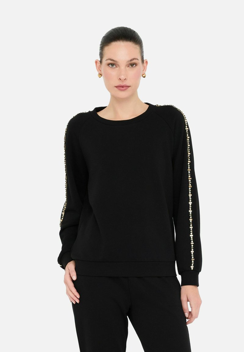 Zwarte sweatshirt met lange mouwen, voorzien van gouden versieringen langs de buitennaad. Gemaakt van zachte stof met een ontspannen pasvorm.