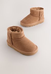 Bottes basses en daim marron avec une doublure intérieure en fausse fourrure douce, un bout arrondi et une semelle en caoutchouc antidérapante avec un simple détail de couture.