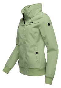 Gaiši zaļš jaka ar augstu apkakli, priekšējo rāvējslēdzēju un sānu kabatām. Iekļautas ribotas aproces un gluda auduma tekstūra. Melni pogu akcenti.