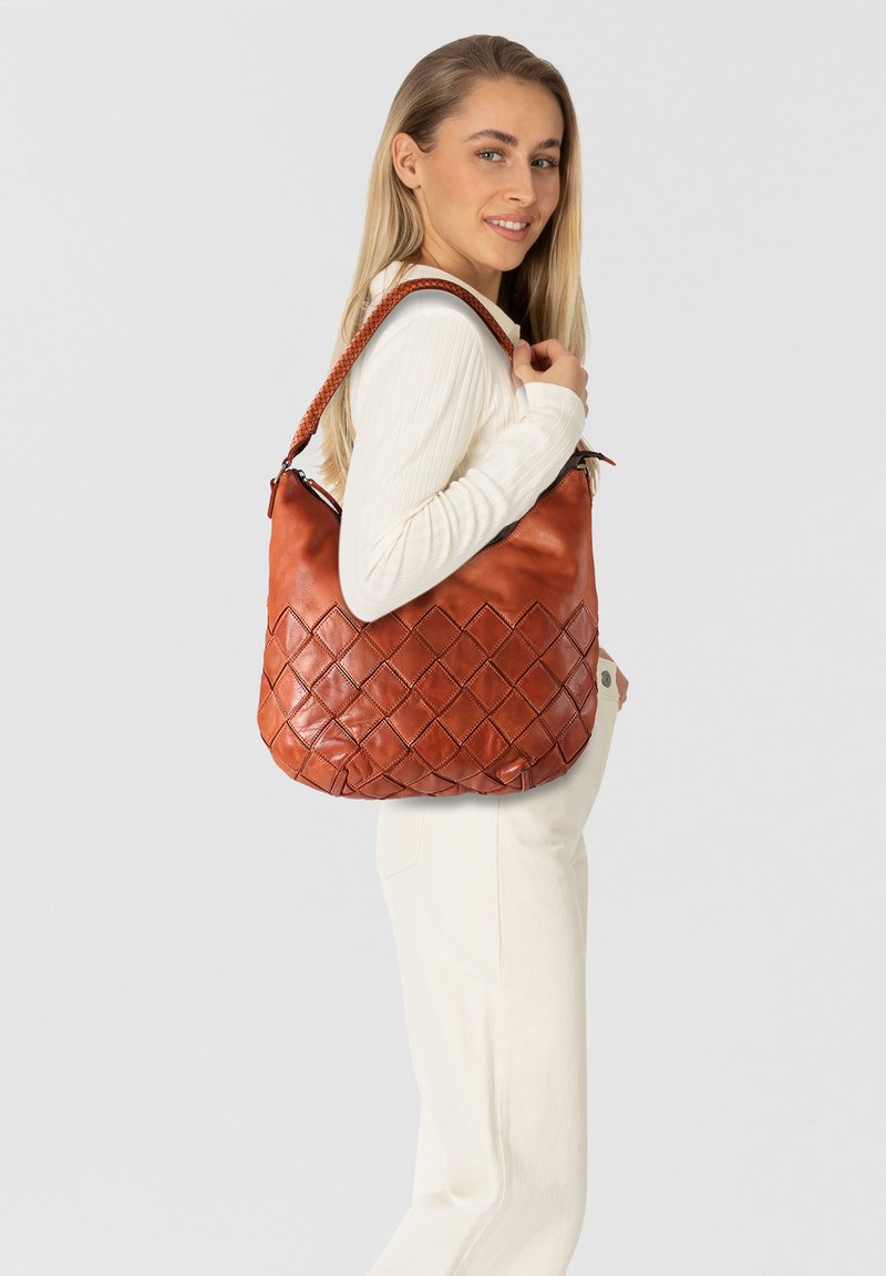 Sac en cuir brun avec un motif de losanges matelassé, doté d'une bandoulière tressée et d'une forme douce et décontractée.