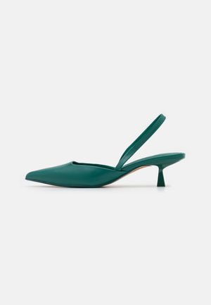 Zielony but na szpilce typu slingback z zaostrzonym noskiem, niskim, lekko zakrzywionym obcasem typu kitten oraz gładką powierzchnią na jednolitym jasnym tle.