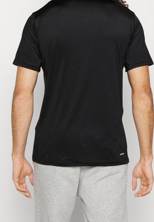 Camiseta deportiva negra de tejido suave, con mangas cortas y un escote redondeado, mostrada desde la parte de atrás con una cinturilla gris en la parte inferior.