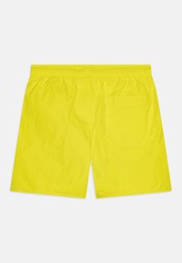 Shorts de bain en nylon jaune avec une taille élastique, dotés d'une poche arrière et d'une texture lisse. Design simple, coupe au genou.