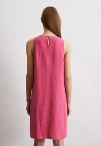 Rosa Leinenkleid ohne Ärmel mit einem Schlüssellochausschnitt, geradem Schnitt und strukturierter Oberfläche. Schlichtes Design ohne zusätzliche Akzente.