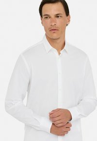 Weißes Button-Up-Hemd mit langen Ärmeln, aus Baumwollmaterial, klassischem Kragen und Manschettendetails; glatte Textur und taillierte Passform.