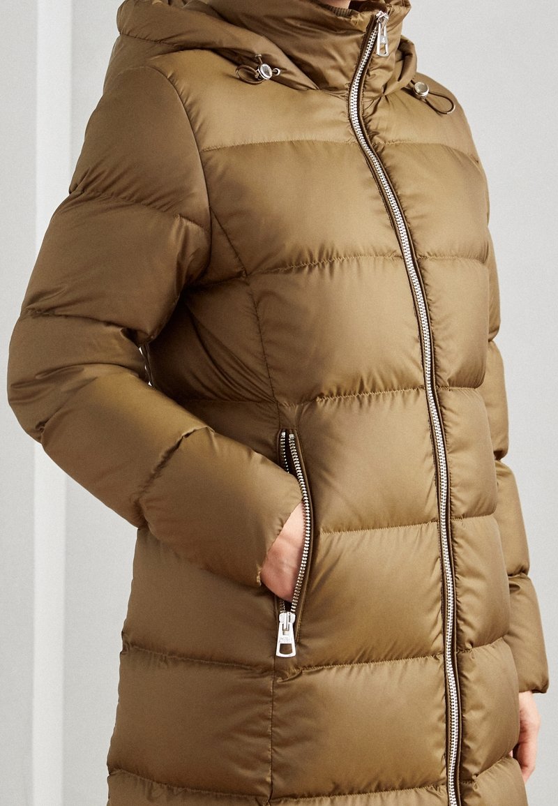 Chaqueta acolchada verde oliva con cremallera al frente, bolsillos laterales y capucha. Presenta un patrón de acolchado horizontal y accesorios de hardware en color plateado.