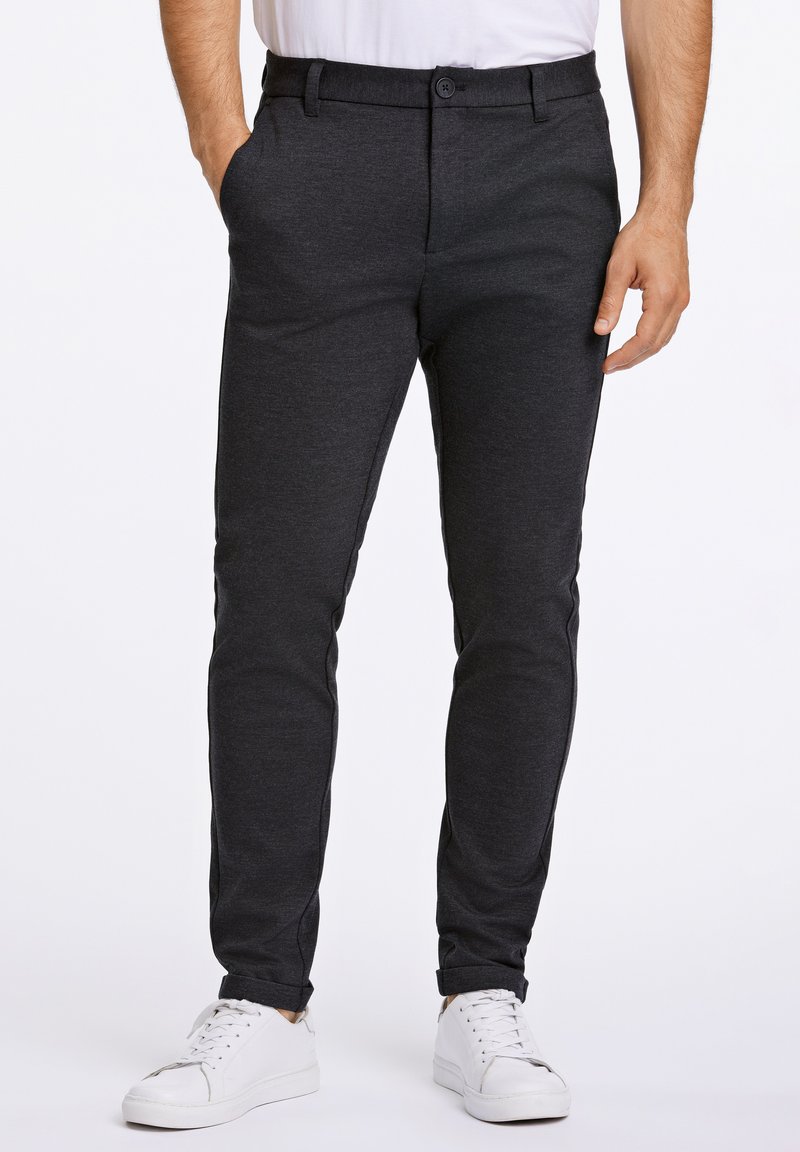 Donkergrijze slim-fit broek gemaakt van een zachte stof, met een knoop- en ritssluiting, zijzakken en een taps toelopend broekspijpontwerp.
