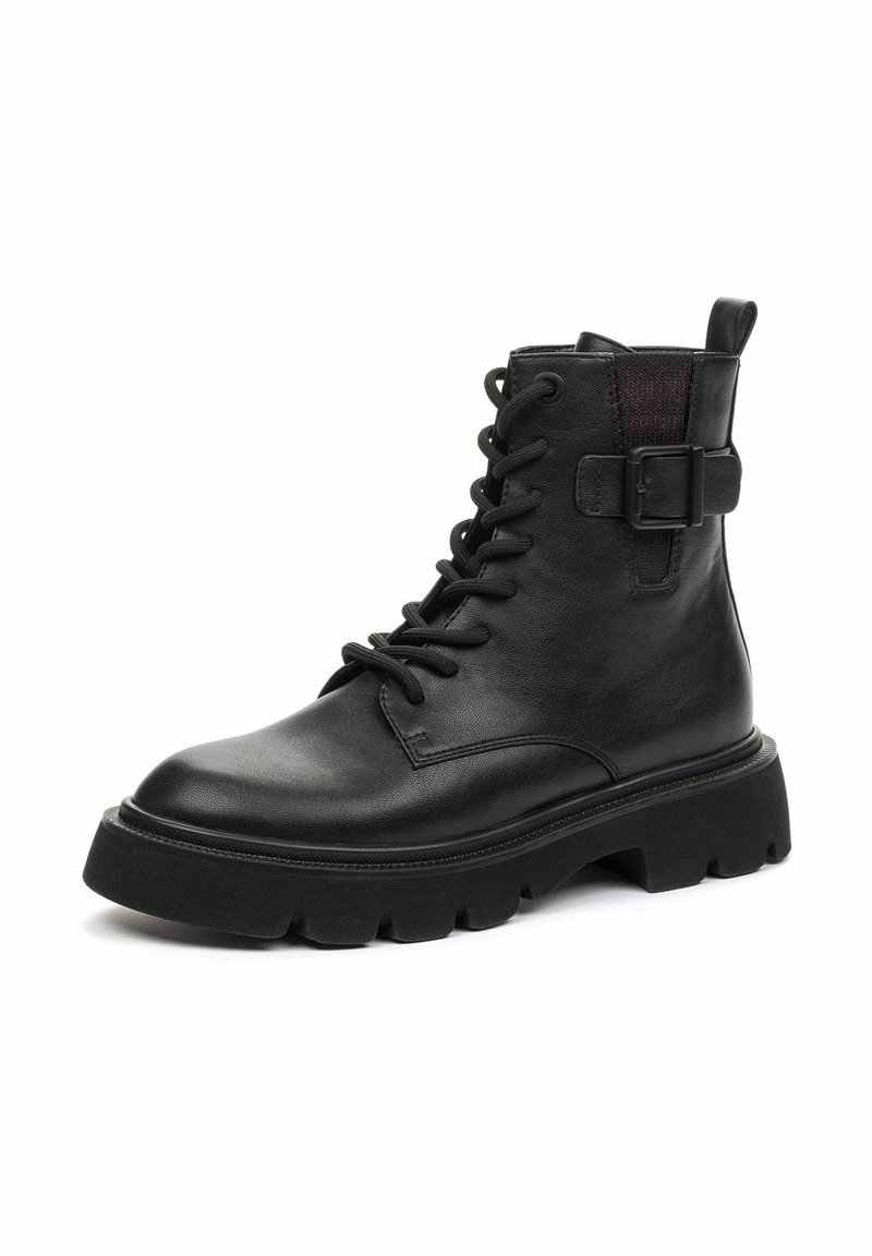 Botte de combat en cuir noir à lacets, semelle épaisse crantée et détail d’une boucle latérale, présentée légèrement en angle sur fond blanc.