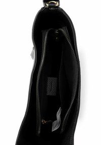 Musta nahkainen käsilaukku, jossa näkyy keskellä vetoketjullinen osio ja kangasetiketit valkoista taustaa vasten.