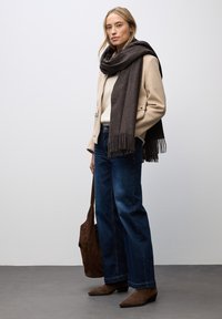 Beige uld-blend frakke, creme sweater, blå vidde jeans, mørkebrun frynset tørklæde og mørkebrune ruskinds ankelstøvler. Brun skuldertaske.