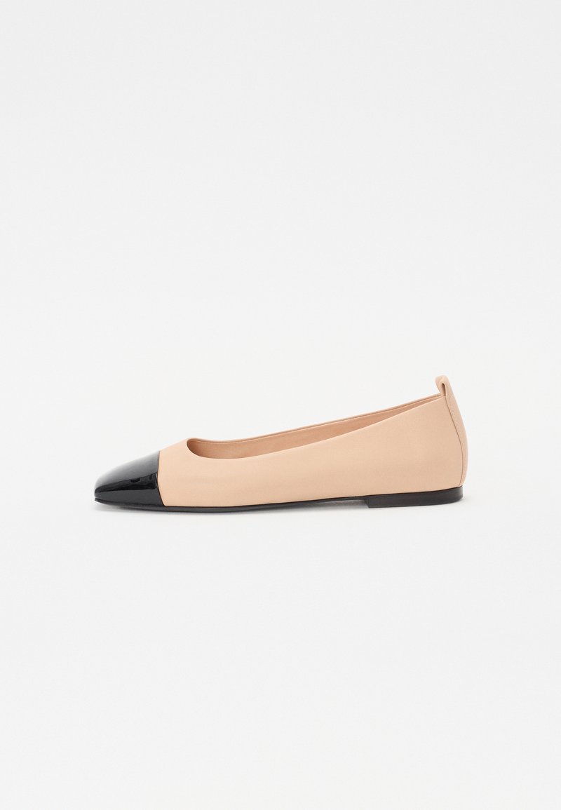 Ballerines avec un dessus en cuir nude et un bout en cuir verni noir ; design minimaliste avec une semelle flexible.