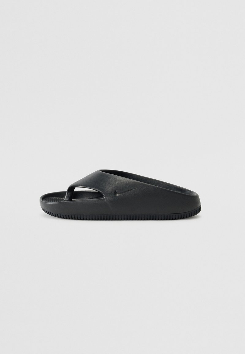 Μαύρη σαγιονάρα με λείες πλαστικές λεπτομέρειες, ανοιχτό μπροστά και μια ενιαία ρίγα. Διαθέτει υφή στην εξωτερική σόλα για πρόσφυση. Εμφανίζεται το λογότυπο της Nike.