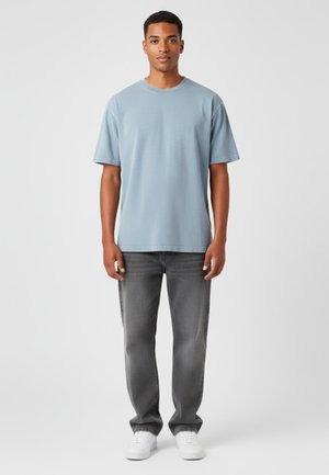 Lichtblauw crewneck t-shirt van zachte stof, gecombineerd met donkergrijze spijkerbroek en witte sneakers, met een recht model en standaard pasvorm.