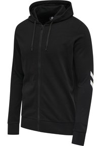 Svart zip-up hoodie med snörning i huvan, långa ärmar och kontrasterande vita ränder på vänster ärm. Mjuk bomullsmaterial.