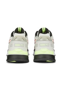 Baskets de course Puma avec une tige en mesh gris clair, des accents noirs, des inserts vert fluo et une semelle noire matelassée avec un logo visible.
