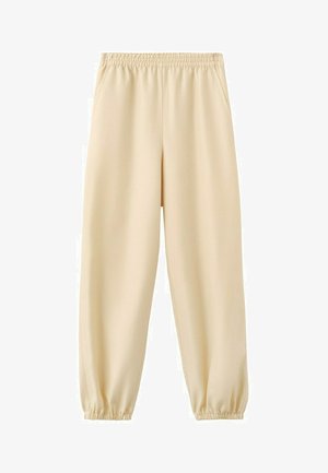 Pantalones jogger beige con cintura y tobillos elásticos, con bolsillos laterales, hechos de tela suave y ligera.