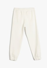 Hvide sweatpants med elastisk talje og indsamlede manchetter ved anklerne. Blødt, struktureret stof med et minimalistisk design.