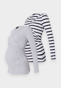 To lange ermelige topper: en grå med vridd frontdesign, den andre hvit med svarte striper. Begge er laget av myk, elastisk tekstil.
