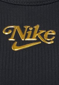 Tissu noir côtelé avec un logo Nike doré en relief et un accent en forme de virgule, placé au centre pour garantir visibilité et image de marque.