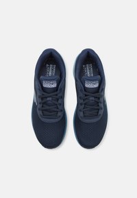Adidași bleumarin cu o parte superioară din plasă respirabilă, închidere cu sireturi și accente bleu deschis pe talpă. Prezintă branding-ul 'SKECHERS GOrun'.