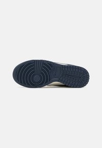 Nike sneaker sole with a textured blue rubber surface featuring circular and horizontal grip patterns. The design includes a centrally placed logo.