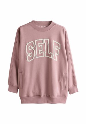 Felpa rosa con la scritta "SELF" in lettere bianche pelose. Presenta uno scollo rotondo, spalle scese e tasche laterali. Tessuto morbido al tatto.