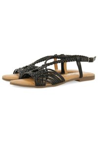 Las sandalias de cuero trenzado negro presentan un diseño de punta abierta con correas trenzadas y un hebilla en el tobillo. La suela es plana y de color marrón claro.