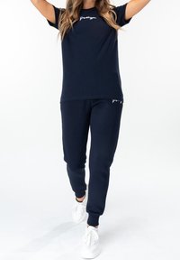 Navy matching t-shirt and sweatpants set, made of soft fabric. T-shirt features a white script logo; pants have a similar logo on the side.