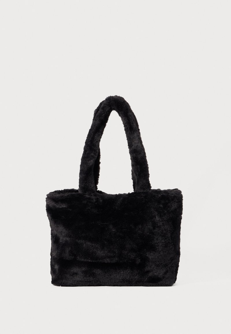 Sac fourre-tout rectangulaire noir avec une texture douce et pelucheuse en fausse fourrure, doté de deux poignées assorties en peluche, sur un fond clair uni.